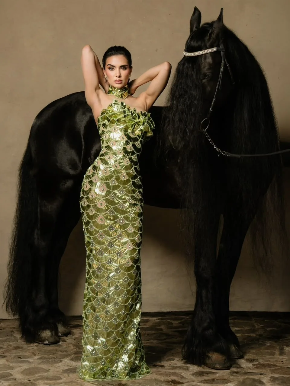 Sesión de moda con vestido verde junto a un Friesian