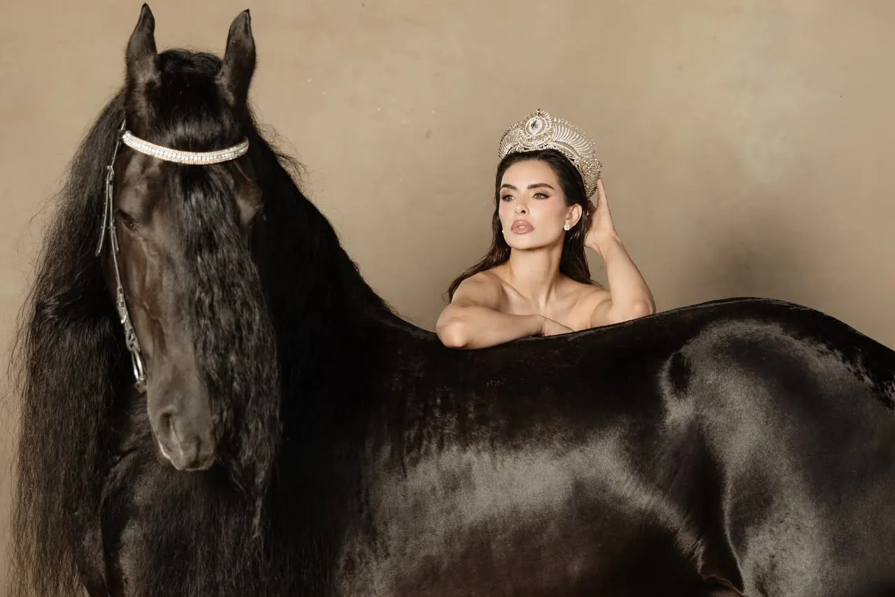 Miss Universe Jalisco recargada sobre un Friesian